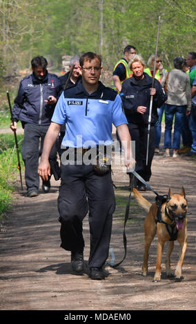 19 April 2018, Germany, Brieselang: A police officer searches a forest ...