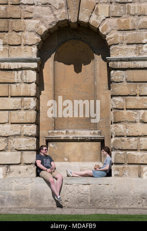 Oxford, UK. 19th April 2018. Oxford University students take a break from studies outside the world-famous Radcliffe Camera, part of the Bodleian Library. Today is predicted to be one of the hottest April days on record, at around 27°C. Credit: Martin Anderson/Alamy Live News. Stock Photo