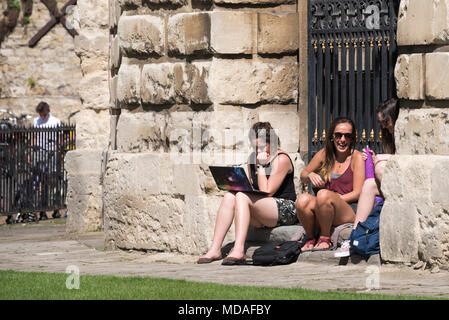 Oxford, UK. 19th April 2018. Oxford University students take a break from studies outside the world-famous Radcliffe Camera, part of the Bodleian Library. Today is predicted to be one of the hottest April days on record, at around 27°C. Credit: Martin Anderson/Alamy Live News. Stock Photo