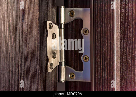 Stainless door hinge on wooden door close Stock Photo