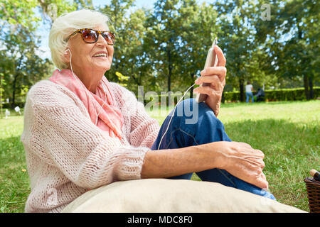 Senior Woman with Smartphone Outdoors Stock Photo