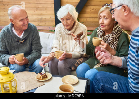 Senior Friends Enjoying Tea Time in Cafe Stock Photo
