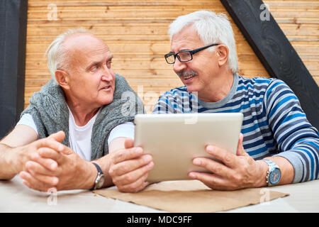 Senior Friends Using Digital Tablet Stock Photo