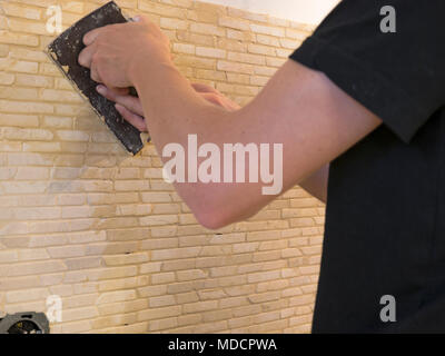 applying mosaic tiles on wall Stock Photo