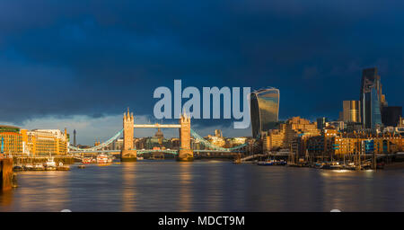 London, England - Beautiful golden sunrise in London with Tower Bridge, St.Paul's Cathedral and skyscrapers of Bank District. Dramatic dark clouds at  Stock Photo
