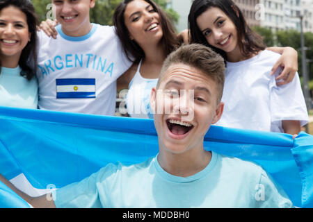 Handsome argentinian sports fan with other supporters from Argentina outdoors on way to stadium Stock Photo