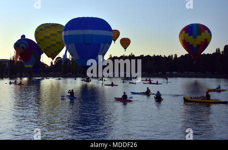 Canberra, Australia - March 11, 2018. Kayakers watching big colourful hot air balloons at Lake Burley Griffin, as part of the Balloon Spectacular Fest Stock Photo