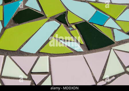 background with Broken tile mosaic in green and pink colors on the exterior facade of a building. Stock Photo