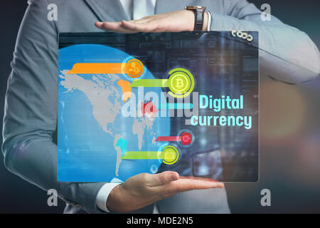 Business, technology, internet and networking concept. Young businessman working on his laptop, select the icon bitcoin on the virtual display. Stock Photo