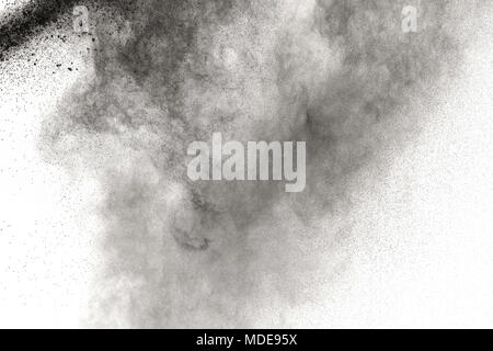 Black powder explosion against white background.The particles of charcoal splattered on white background. Closeup of black dust particles explode isol Stock Photo