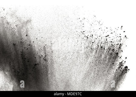 Black powder explosion against white background.The particles of charcoal splattered on white background. Closeup of black dust particles explode isol Stock Photo