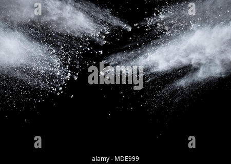 Bizarre forms of  white powder explosion cloud against dark background. Launched white particle splash on black background Stock Photo
