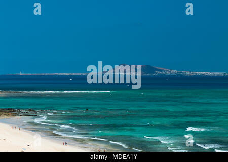 View from Corralejo in Fuerteventura, Spain to Lanzarote with the Montana Roja and the Faro de Pechiguera to the left. Stock Photo