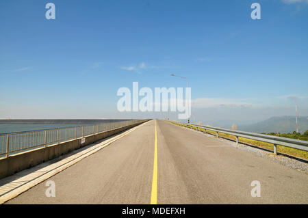 Long and empty straight road running to nowhere with blue sky background Stock Photo
