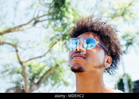 Man wearing sunglasses, looking up Stock Photo