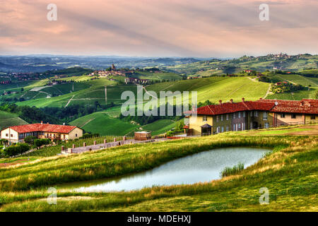 A wide view of the hills of the Langhe cultivated with vineyards and dotted with farms and wineries around the village of Serralunga d'Alba. Stock Photo