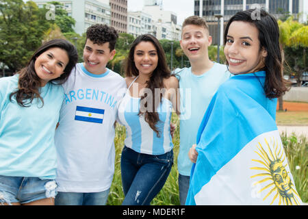 Laughing argentinian sports fan with other supporters from Argentina outdoors on way to stadium Stock Photo