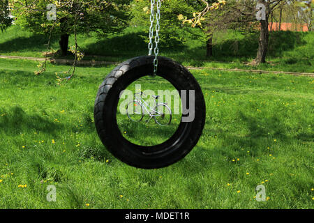 Vintage bicycle framed with hanging car tire Stock Photo