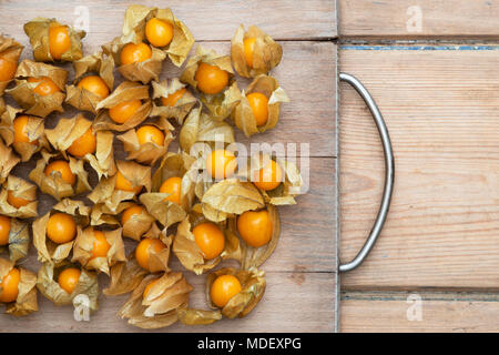 Physalis peruviana. Cape gooseberry fruit on a wooden board Stock Photo