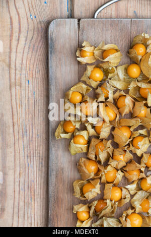 Physalis peruviana. Cape gooseberry fruit on a wooden board Stock Photo