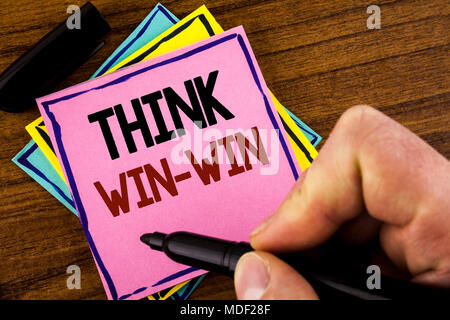 Word writing text Think Win-Win. Business concept for Negotiation strategy for both partners to obtain benefits written by Man Pink sticky note paper  Stock Photo