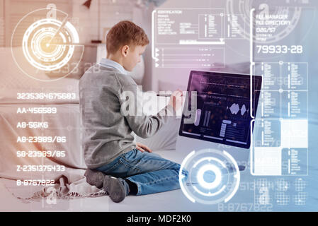 Concentrated child using a modern stylus while doing homework Stock Photo