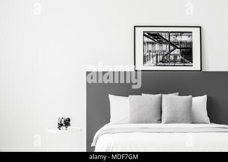 White bed with black bedhead in contrast bedroom interior with poster and copy space Stock Photo
