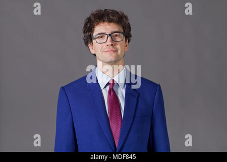 Intellectual boy with curly hair, glasses and blue jacket Stock Photo