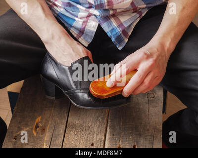 Close up of a man cleaning female leather shoes Stock Photo