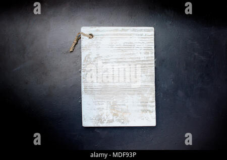 white kitchen cutting board of rectangular shape with a rope lies on a black background. top view, copy space Stock Photo