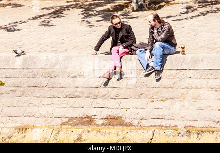 People are sitting on the embankment of the river Sena. Paris, France Stock Photo