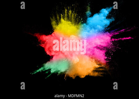 Multi color powder explosion isolated on black background. Colored dust splash cloud on black background. Launched colorful particles on background. Stock Photo