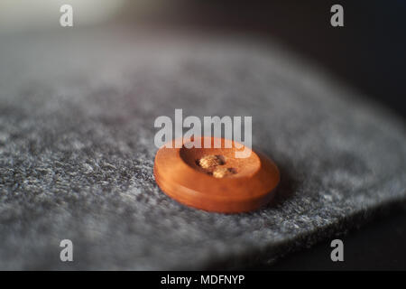 Sewn button playing with light, shadow, reflection and surfaces, selective focus. Stock Photo