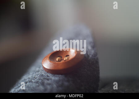 Sewn button playing with light, shadow, reflection and surfaces, selective focus. Stock Photo