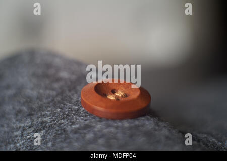 Sewn button playing with light, shadow, reflection and surfaces, selective focus. Stock Photo