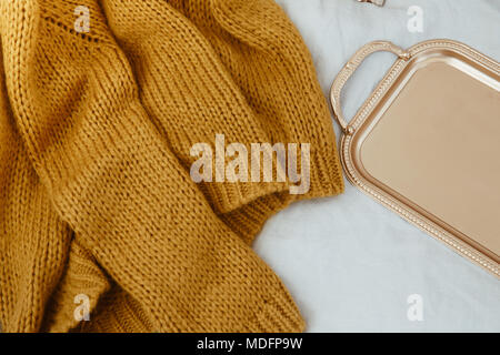 Knitted sweater and a gold colored tray Stock Photo
