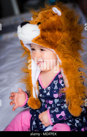 Portrait of a smiling baby girl wearing an animal hat