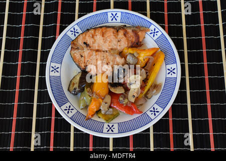 Salmon with grilled veggies. Fish fillet with peppers mushrooms onion eggplant and zucchini. Stock Photo