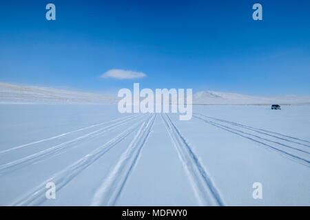 Tyre tracks in the snow and a parked vehicle, Baikal Lake, Irkutsk Oblast, Siberia, Russia