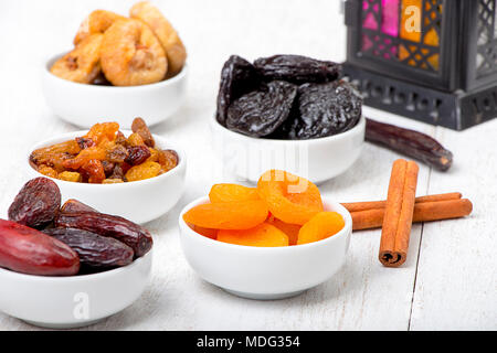 Ramadan Sweets - Dried Fruits ( Dates , Apricots , Prunes , Raisins , and Figs ) with Lantern on Wooden Table Stock Photo