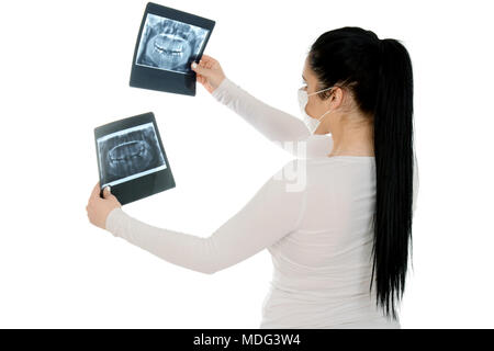 X-ray of a human jaw in the hands of the dentist. Beautiful girl holding x-ray, wearing protective mask. Stock Photo