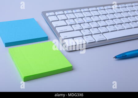 Office desk with keyboard and stikers, papers Stock Photo
