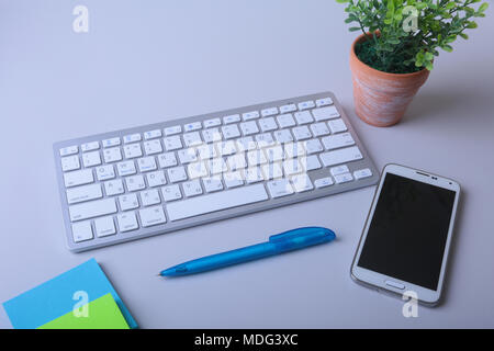 Office desk with keyboard and stikers, papers Stock Photo