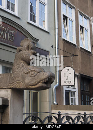 Rainwater drainage from a roof in the Main Town in Gdansk Poland can pour out of such fantasy creatures in carved stone Stock Photo