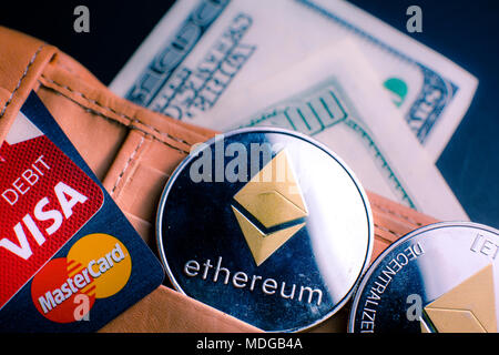 Ethereum (ETH) cryptocurrency in leather wallet with credit cards of MesterCard and Visa and blurred one hundred dollar on background Stock Photo