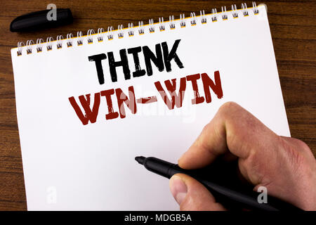 Word writing text Think Win-Win. Business concept for Negotiation strategy for both partners to obtain benefits written by Man Notepad holding Marker  Stock Photo