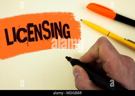 Writing note showing  Licensing. Business photo showcasing Grant a license Legally permit the use of something Allow activity written by Man holding M Stock Photo