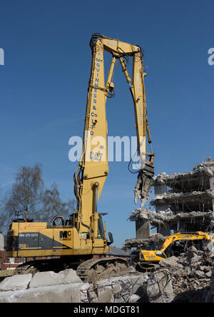 Caterpillar 350L high reach demolition excavator with concrete crusher attachment and partly demolished concrete building on demolition site,  bury uk Stock Photo