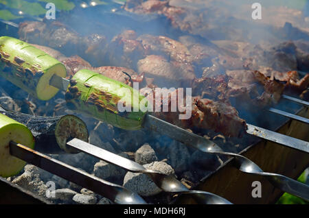 Marinated shashlik with squashes preparing on a barbecue grill over charcoal. Shashlik or Shish kebab popular in Eastern Europe. Shashlyk (skewered me Stock Photo