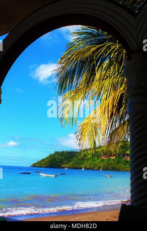 View through an arch of a secluded beach on the Caribbean island of St Vincent. Stock Photo